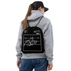 May include: Black drawstring bag with a white football play diagram and the text "Corn Dog" on the front.
