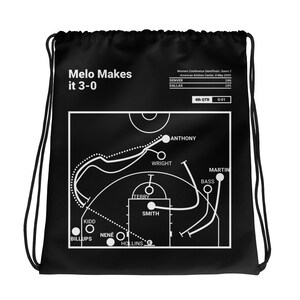以下が含まれることがあります： 黒い巾着袋。白いバスケットボールのプレー図が描かれています。「Melo Makes it 3-0」のテキストが左上にあります。図には選手の名前と試合の詳細が含まれています。スポーツをテーマにしたアクセサリーです。