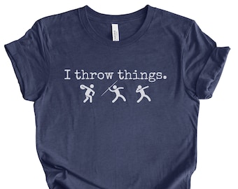 May include: Navy blue t-shirt with the text "I throw things." and three white stick figures representing different throwing sports.