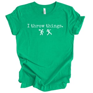May include: A green t-shirt with the text "I throw things." and a white silhouette of two people throwing a ball.