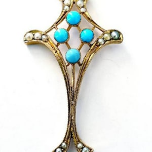 May include: A vintage gold-tone pendant necklace featuring a cross-shaped design. The pendant is adorned with turquoise cabochons and small pearls. The necklace has a delicate chain.