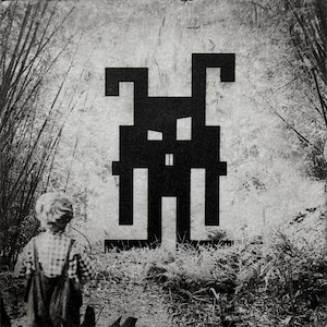 Op de afbeelding: Zwart-wit kunstwerk met een gepixelde figuur tegen een getextureerde achtergrond. Een kind in een tuinbroek staat op de voorgrond en kijkt naar het kunstwerk. De scène speelt zich af in een natuurlijke omgeving met bamboe en gebladerte.