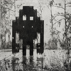 Op de afbeelding: Zwart-wit kunstwerk van een geometrische figuur in het water, met een moerassige achtergrond. De figuur heeft een blokkerig ontwerp met vierkante en driehoekige details en lijkt te druipen. Bomen en vegetatie omringen het water.