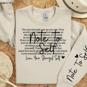 Peut inclure: Un sweat-shirt beige avec une citation de motivation imprimée sur le devant. La citation dit : "Vous êtes assez bien comme vous êtes. Votre valeur n'est pas liée aux réalisations ou aux opinions des autres, elle est ancrée dans votre lumière unique et votre force. Même les jours difficiles, souvenez-vous de combien de chemin vous avez parcouru et de votre capacité à vous relever. Parlez-vous avec gentillesse. Traitez-vous avec le même amour que vous donneriez à quelqu'un qui vous tient à cœur. Aimez-vous avec passion, vous le méritez. Avec amour, votre moi le plus fort." La manche du sweat-shirt porte l'inscription "Note To Self" imprimée dessus.