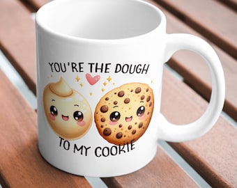 May include: White ceramic mug with a cute illustration of a cookie and dough with the text "You're the dough to my cookie".