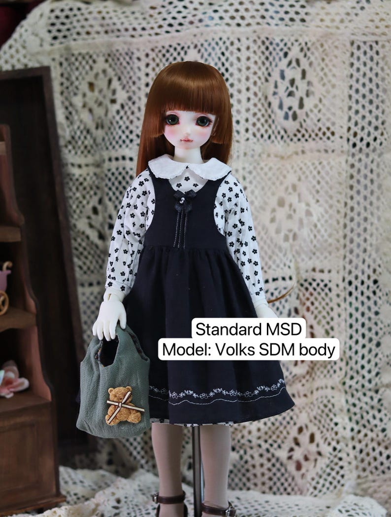 Pode incluir: Uma boneca vestindo um vestido preto e branco com uma gola branca e uma bolsa verde com um urso de pel&uacute;cia. A boneca tem cabelo castanho e olhos verdes. A boneca &eacute; um modelo Standard MSD: Volks SDM body.