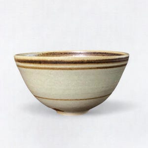 May include: A small, white ceramic bowl with brown stripes around the rim. The bowl has a slightly rounded shape and a smooth, glazed finish.