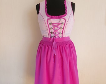 May include: A pink and white dirndl with a white and pink checkered bodice, a pink skirt, and a white and pink checkered trim. The bodice has a lace-up front with silver buttons and a pink ribbon.