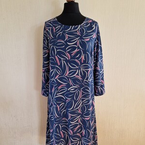 May include: A long-sleeved dress with a blue background and a white and pink abstract leaf pattern.