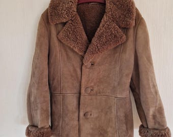 May include: A brown suede and shearling coat with a large collar and button closure.
