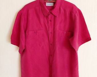 Könnte beinhalten: Ein rosa kurzärmeliges Hemd mit Knöpfen und zwei Brusttaschen. Das Hemd trägt den Markennamen "LAMBERTO" auf dem Etikett.