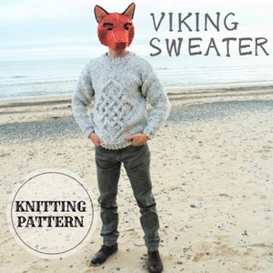 May include: A man wearing a grey knitted sweater with a cable knit pattern and the text "VIKING SWEATER" on the top. The sweater is being worn on a beach with a circle that says "KNITTING PATTERN" in the bottom left corner.