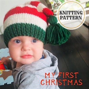May include: A baby wearing a red, white, and green striped knitted hat with a green pom-pom. The hat has the text "Knitting Pattern" on it. The baby is wearing a gray sweater and the text "My First Christmas" is on the bottom of the image.
