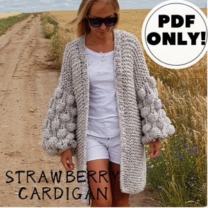May include: A grey knitted cardigan with large, puffy sleeves. The cardigan is open at the front and has a simple, classic design. The text "Strawberry Cardigan" is visible at the bottom of the image. The text "PDF ONLY!" is visible in a circle at the top right of the image.