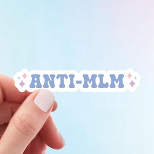 May include: A blue and white sticker with the text "ANTI-MLM" in a retro font. The sticker has small pink and blue diamond shapes on either side of the text.