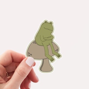 Frog Sticker | Cute & Silly Frog On A Mushroom, Cottagecore Weatherproof Vinyl Sticker by Hello Happy Designs