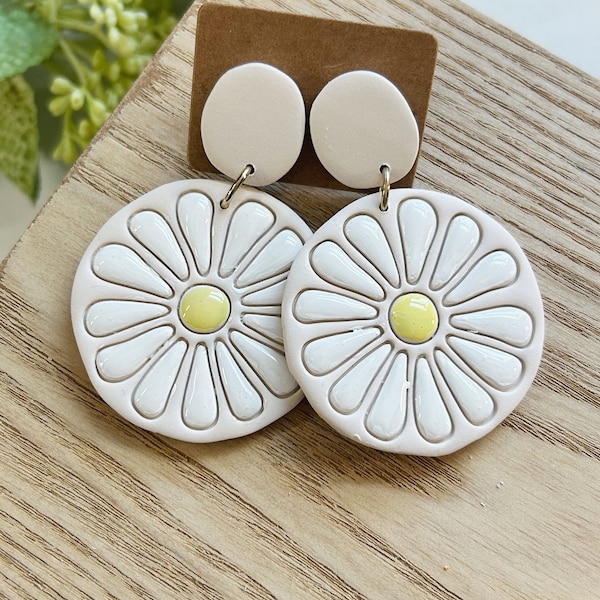 Classic size, embossed and hand painted,  resin coated white and yellow daisy on a cream clay earring linked to a cream clay stud post