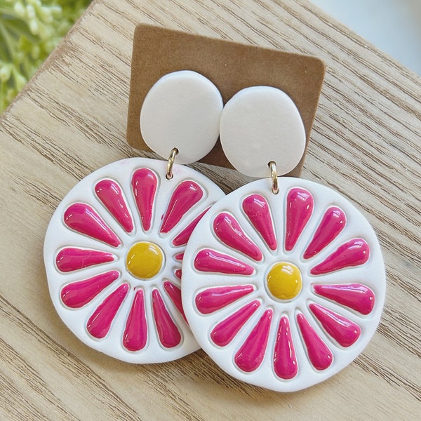 Classic size, embossed and hand painted, resin coated magenta and yellow daisy on a white clay earring linked to a white clay stud post