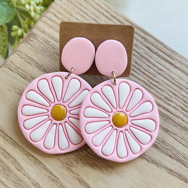 Classic size, embossed and hand painted,  resin coated white and yellow daisy on a light pink clay earring linked to a light clay stud post