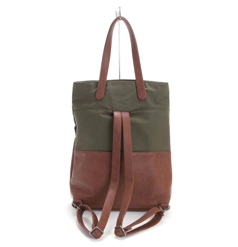 May include: A green and brown canvas and leather tote bag with adjustable straps that can be worn as a backpack.