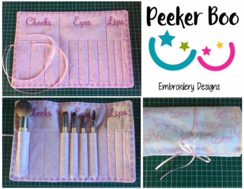 May include: A pink makeup brush roll with embroidered sections labeled "Cheeks", "Eyes", and "Lips". The roll is rolled up and tied with a pink ribbon. The roll is on a green surface. The image also includes a logo for "Peekeer Boo Embroidery Designs" with a blue and pink smiley face design.