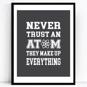 Peut inclure: Une impression encadrée en noir et blanc avec un fond gris et un texte blanc qui dit "NEVER TRUST AN ATOM THEY MAKE UP EVERYTHING".