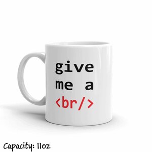 K&ouml;nnte beinhalten: Wei&szlig;e Keramiktasse mit schwarzem Text, der "give me a <br/>" lautet, wobei das "br" rot ist.