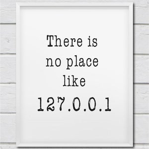 May include: A white framed print with the text "There is no place like 127.0.0.1" in black typewriter font.
