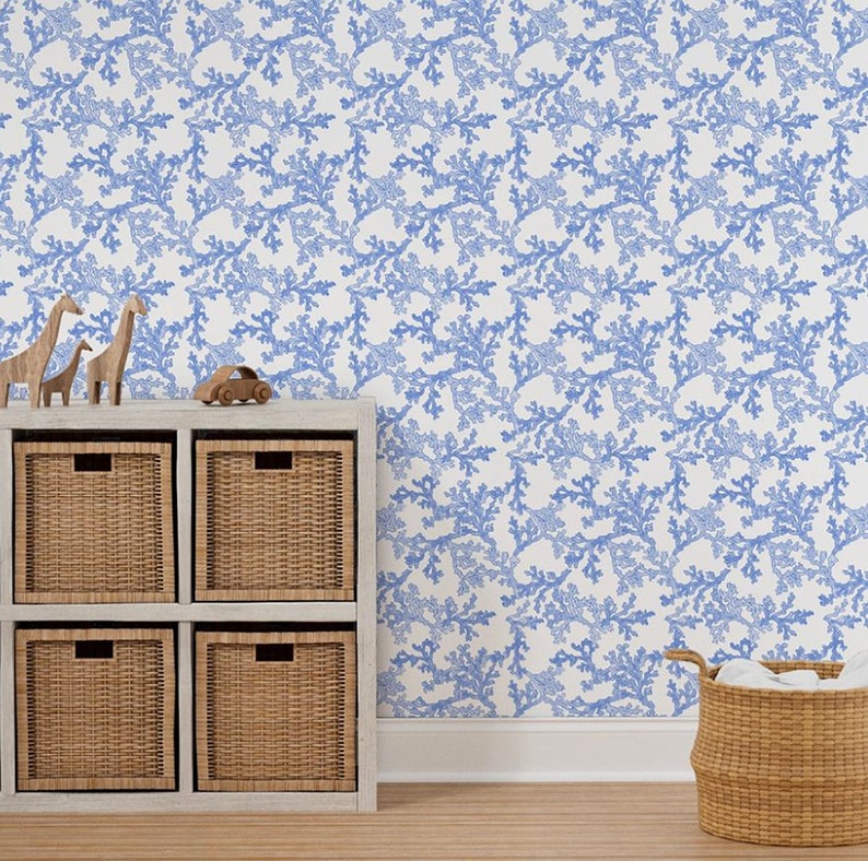 Light blue coral wallpaper on the wall of a nursery decorated with baskets and wooden toys.