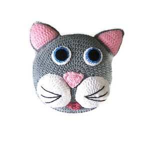 Op de afbeelding: Een grijs gehaakt kattenhoofd met roze oren, witte snorharen en blauwe ogen.