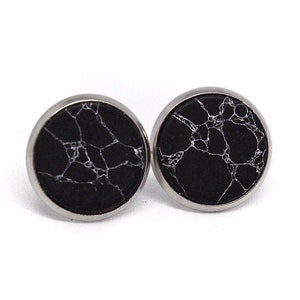 May include: A pair of black and white marble stud earrings with silver settings.