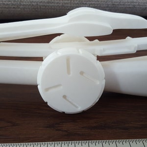Puede incluir: Modelo de brazo de robot impreso en 3D en pl&aacute;stico blanco con una junta redonda segmentada.