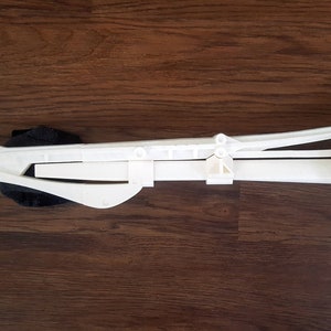Puede incluir: Un arma de utiler&iacute;a de pl&aacute;stico blanco con una cuchilla y un mecanismo giratorio. El arma est&aacute; dise&ntilde;ada para parecer un arma futurista.