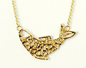 May include: A gold chain necklace with a delicate, textured fish pendant.