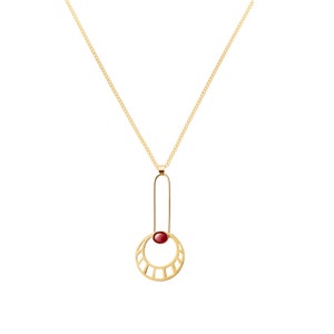 May include: A gold necklace with a pendant featuring a red gemstone set in a geometric circle design.
