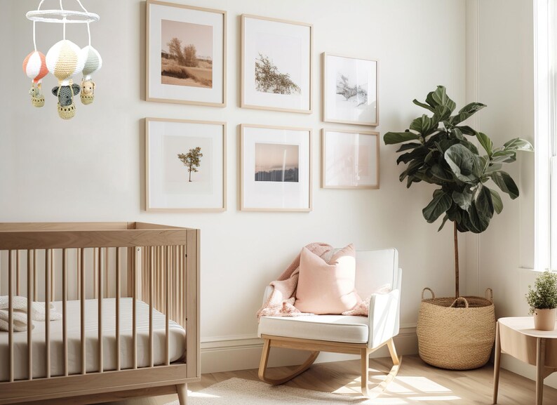 May include: A white rocking chair with a pink pillow in a nursery with a crib, a plant in a woven basket, and framed artwork on the walls.