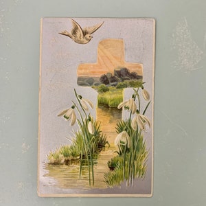 Cartolina di Pasqua con croce e gigli in rilievo su sfondo argento. Cartolina di Pasqua.