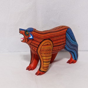 5.5 Inches in Height Original Handmade, Hand Painted Animal, Wood Carving with Irate Eyes, Copper Colored Tail, Colorful Patterned Body, Blue Colored Hind legs, Bear Alebrije, Oaxaca Art, Unique Statue from https://luv2brd.etsy.com