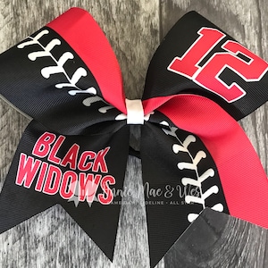 May include: Black and red cheer bow with a baseball stitch design. One side says "Black Widows" and the other side has the number "12" on it.