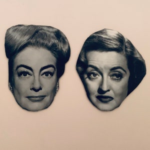 May include: Black and white photo of two women's faces. The women are looking at the camera with serious expressions. The photo is printed on a white background.