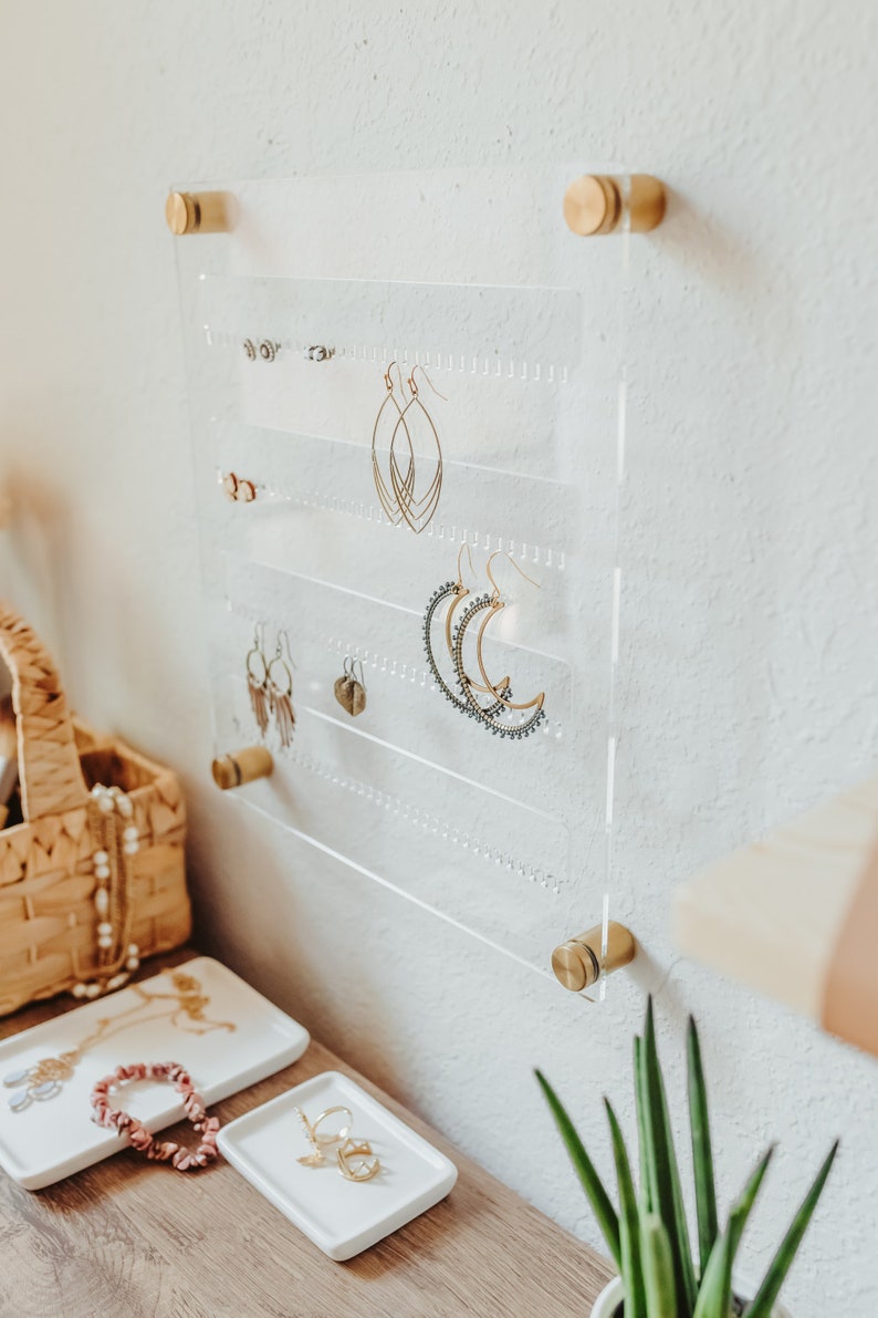 Modern Clear Acrylic Earring Storage with Stud and Dangling Earrings on display above a desk with house plant