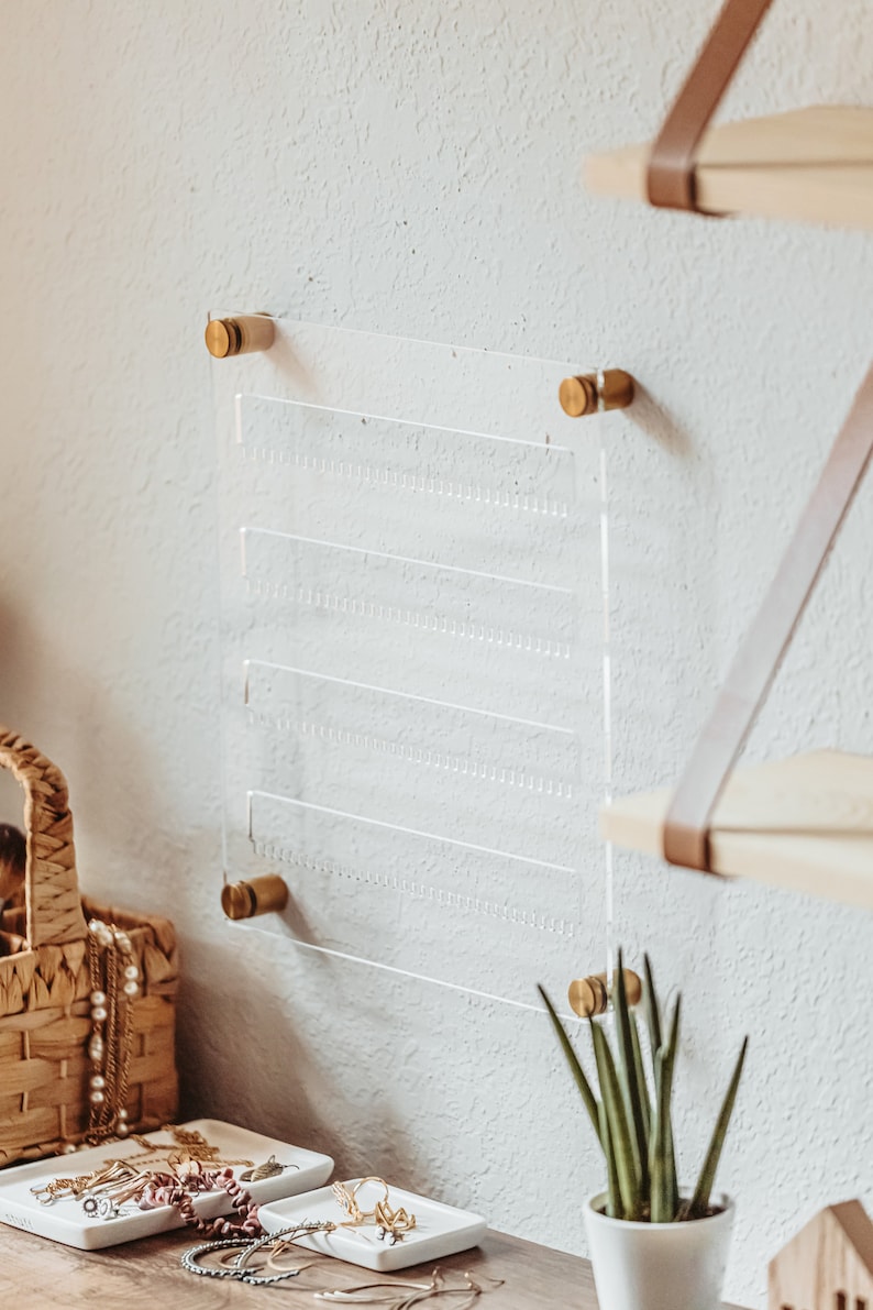 Modern Clear Acrylic Earring Storage with Stud and Dangling Earrings on display above a desk with house plant