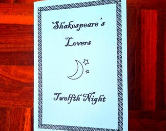 May include: A light blue card with the text "Shakespeare's Lovers Twelfth Night" in elegant script. A crescent moon and star are also featured. The card has a decorative border and is displayed on a wooden surface.