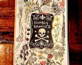 May include: An open book with a botanical theme, featuring a black and white skull and crossbones emblem with the text "Deathly Botanica II." The pages are filled with colorful illustrations of various flowers and plants.