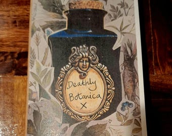 May include: A dark blue apothecary bottle with a cork stopper and a decorative label that reads "Deathly Botanica X." The label features a woman's face in an ornate gold frame. The background has botanical illustrations.