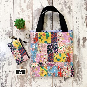 May include: A patchwork tote bag with black handles and a small matching zippered pouch. The bag and pouch feature a colorful floral pattern with a variety of colors, including pink, yellow, blue, and green.