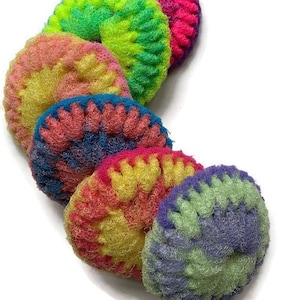 May include: Six colorful crocheted dish scrubbers in a rainbow of colors, including pink, green, yellow, blue, and purple. The scrubbers are arranged in a semi-circle.
