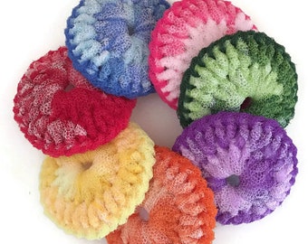 Puede incluir: Un conjunto de siete estropajos de ganchillo de colores en forma de rosquilla. Los estropajos están hechos de un material suave y texturizado y son perfectos para limpiar platos u otras superficies.
