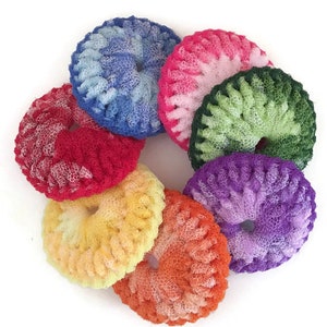May include: A set of seven colorful, crocheted scrubbers in the shape of a donut. The scrubbers are made of a soft, textured material and are perfect for cleaning dishes or other surfaces.