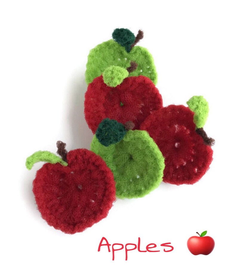 Puede incluir: Un grupo de cinco manzanas de ganchillo, tres rojas y dos verdes, con una sola ilustraci&oacute;n de manzana roja debajo del texto "Manzanas".